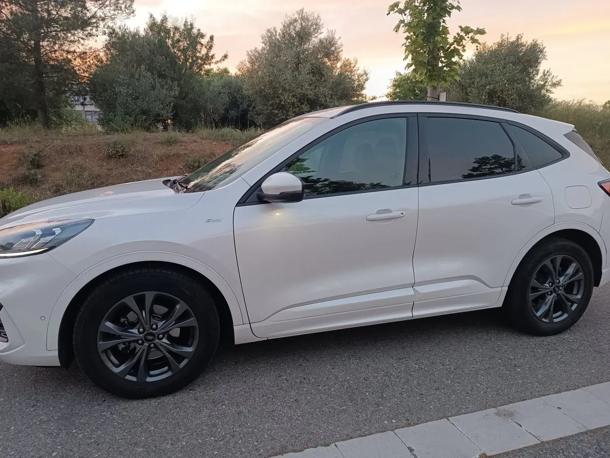 Ford Kuga blanco aparcado en la calle, visto de lado