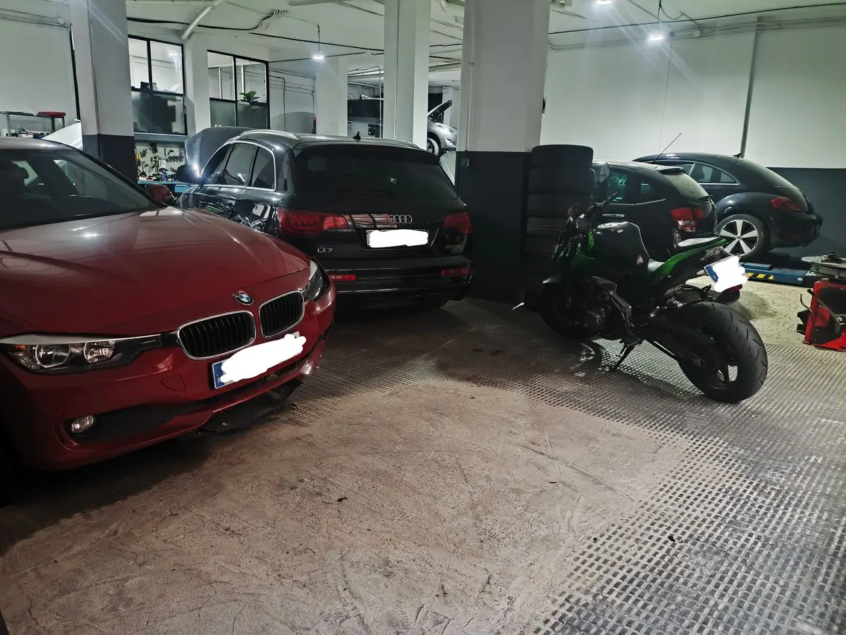 Coches y una moto dentro de la nave del taller YaCar Motor, en Reus